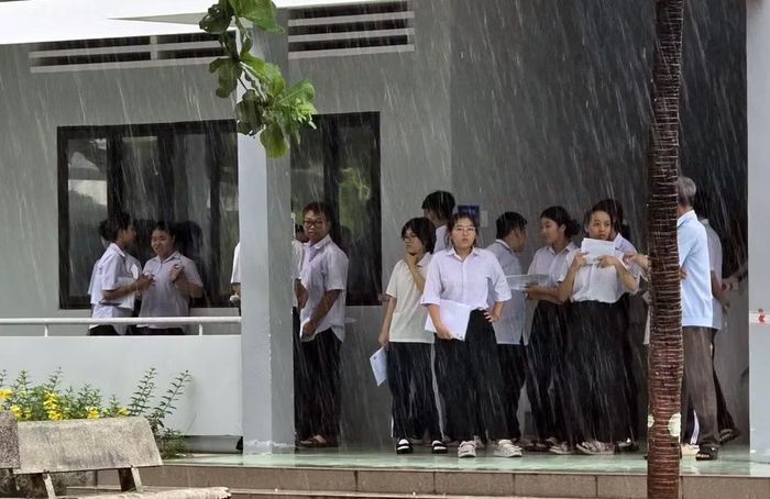 Thí sinh Côn Đảo thi xong môn Ngữ văn, đứng đợi hết mưa.
