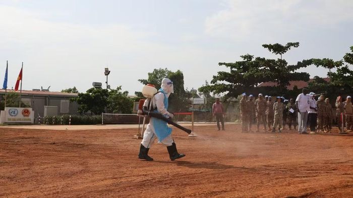 Nhân viên y tế Bệnh viện dã chiến cấp 2 số 7 thực hành khử khuẩn lối di chuyển và các khu vực liên quan đến trường hợp nghi nhiễm Ebola trong tình huống diễn tập. (Ảnh: TIẾN PHÚC)