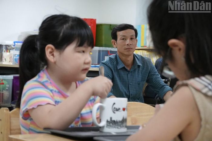 Anh Ngải dõi theo con trong lớp học. (Ảnh: Hà Thương)