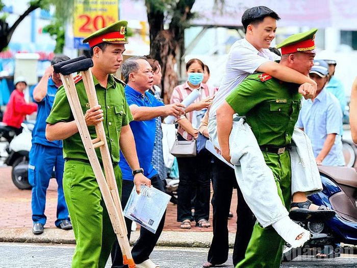Cán bộ Công an Cà Mau trực tiếp hỗ trợ em Lê Đăng Khoa đến phòng thi tại Trường trung học phổ thông Hồ Thị Kỷ an toàn.