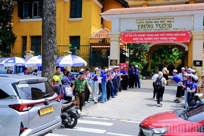 Tại cổng trường, lực lượng tình nguyện viên áo xanh xếp hàng tạo thành lối đi và hỗ trợ, khích lệ tinh thần giúp các thí sinh vững tâm lý bước vào môn thi thứ hai trong ngày thi hôm nay.