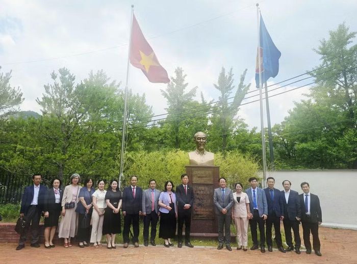 Cán bộ Đại sứ quán và Đoàn công tác tỉnh Gia Lai chụp ảnh kỷ niệm bên tượng Chủ tịch Hồ Chí Minh trong khuôn viên Đại sứ quán.