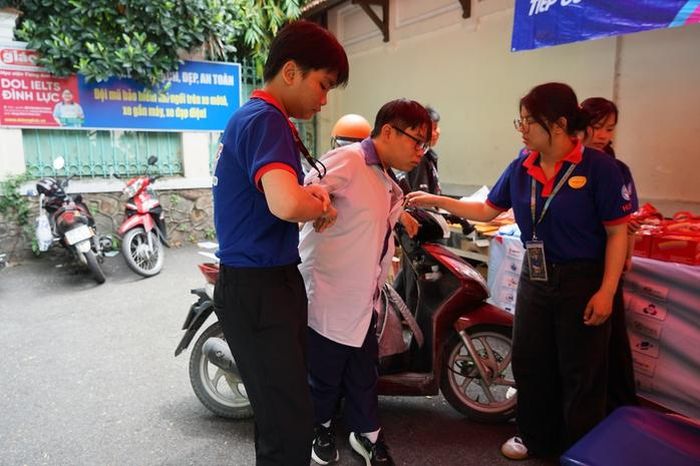 Thí sinh có hoàn cảnh đặc biệt được tình nguyện viên hỗ trợ chiều 11-6 tại điểm thi Trường THPT Lê Quý Đôn (phường Xuân Hòa).