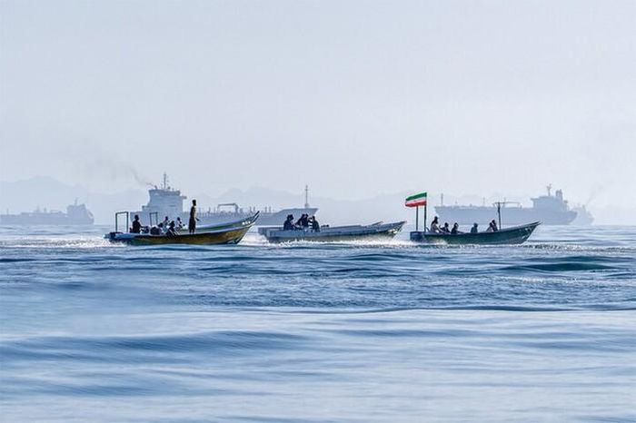 Các tàu nhỏ của quân đội Iran tại khu vực gần eo biển Hormuz, phía xa là các tàu thương mại đang neo đậu - Ảnh: MEHR