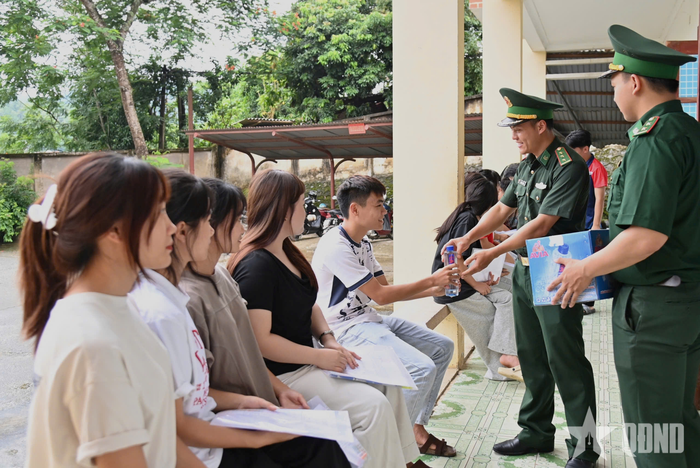 Cán bộ, chiến sĩ Đồn Biên phòng cửa khẩu Ma Lù Thàng phát nước uống cho các thí sinh tại điểm thi Trường THPT Phong Thổ (xã Phong Thổ, tỉnh Lai Châu) trước giờ làm thủ tục dự thi.