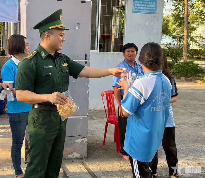 Cán bộ Đồn Biên phòng Vĩnh Nguơn phát nước cho các em học sinh Trường THPT Châu Thị Tế trước khi các em vào phòng thi. Ảnh: HOÀNG KHANG