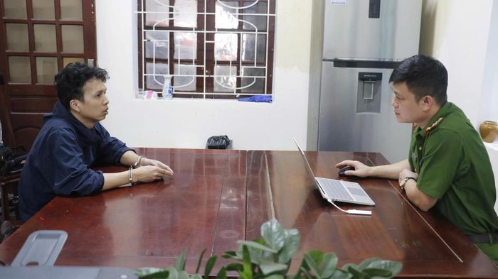 Cán bộ điều tra đấu tranh với đối tượng cầm đầu đường dây Nguyễn Văn Tuấn.