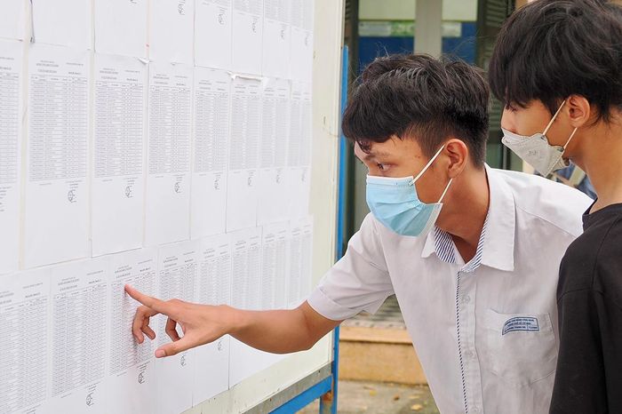  Thí sinh dò tìm tên và số báo danh trên danh sách niêm yết tại điểm thi Trường THPT Lê Quý Đôn, phường Xuân Hòa, TPHCM chiều 10-6. Ảnh: HOÀNG HÙNG 