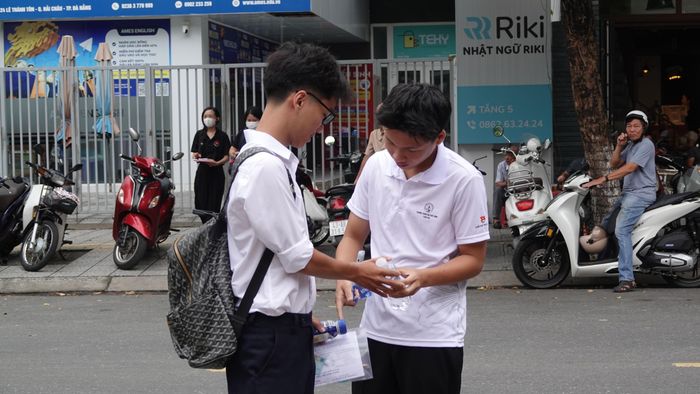 Thí sinh tháo nhãn chai nước trước khi mang vào phòng thi theo quy định. Ảnh: XUÂN QUỲNH