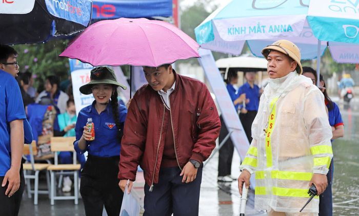 Lực lượng chức năng hỗ trợ thí sinh đi thi dù Đà Lạt có mưa lớn. Ảnh: ĐOÀN KIÊN
