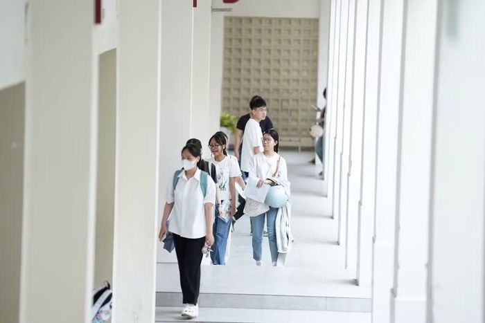 Thí sinh di chuyển về tại phòng gửi vật dụng cá nhân trước khi vào phòng thi tại Điểm thi Trường THPT Phan Châu Trinh.