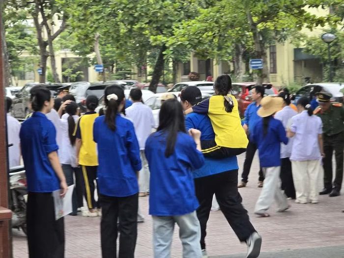 Tình nguyện viên hỗ trợ thí sinh vào Điểm thi Trường THPT Tống Văn Trân trước giờ thi môn Ngữ văn sáng 11/6.