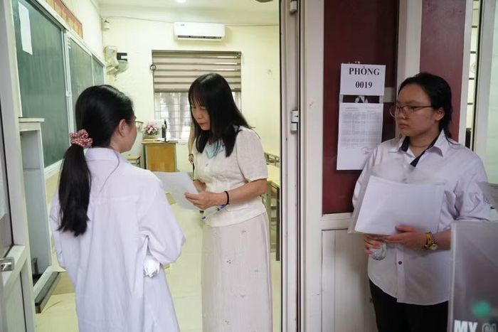 Giám thị kiểm tra thông tin thí sinh trước khi vào phòng thi. Ảnh: Hồ Lài