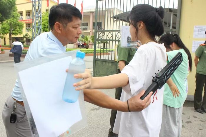 Lực lượng công an phối hợp cán bộ làm nhiệm vụ sử dụng máy quét an ninh cầm tay kiểm tra thí sinh trước khi vào khu vực thi