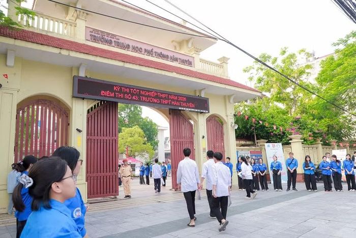 Tình nguyện viên xếp hàng vỗ tay động viên thí sinh dự thi.