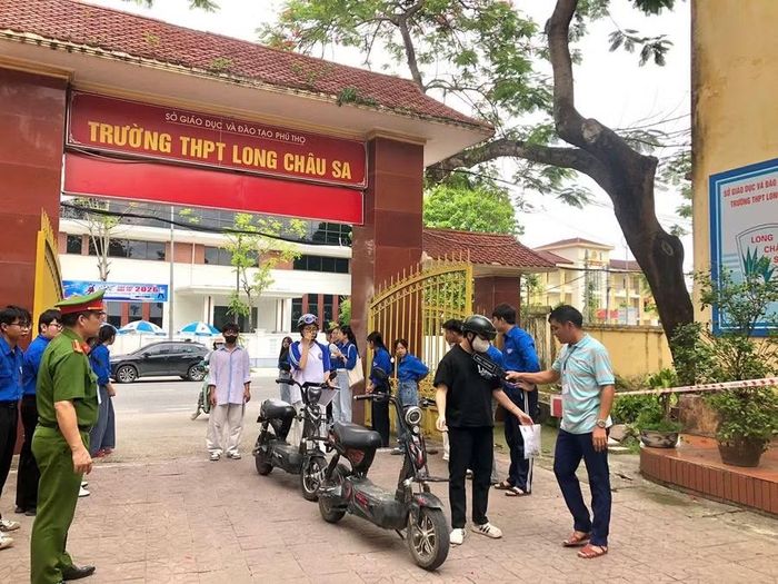 Các thí sinh được kiểm tra bằng thiết bị dò kim loại cầm tay trước khi vào Điểm thi Trường THPT Long Châu Sa (xã Lâm Thao).