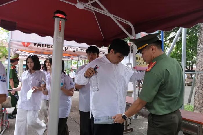 Thí sinh đi qua cửa từ có máy quét cầm tay của lực lượng chức năng.