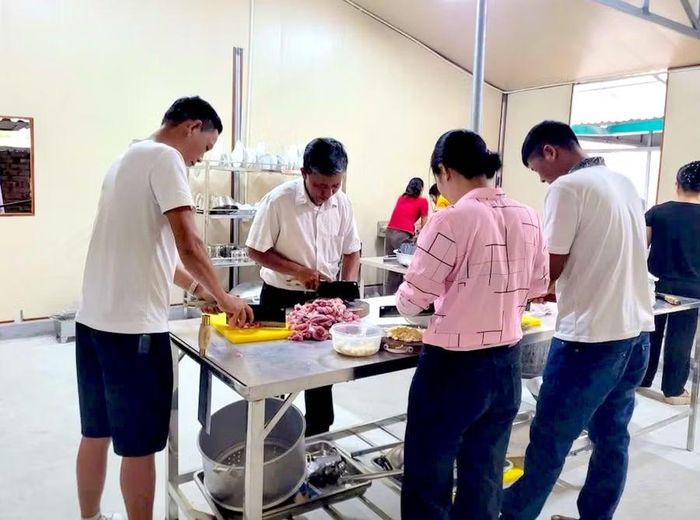 Ngay từ sáng sớm, nhiều phụ huynh đã có mặt tại Trung tâm để cùng thầy cô chuẩn bị nguyên liệu, nấu ăn và chia suất cơm cho học sinh.