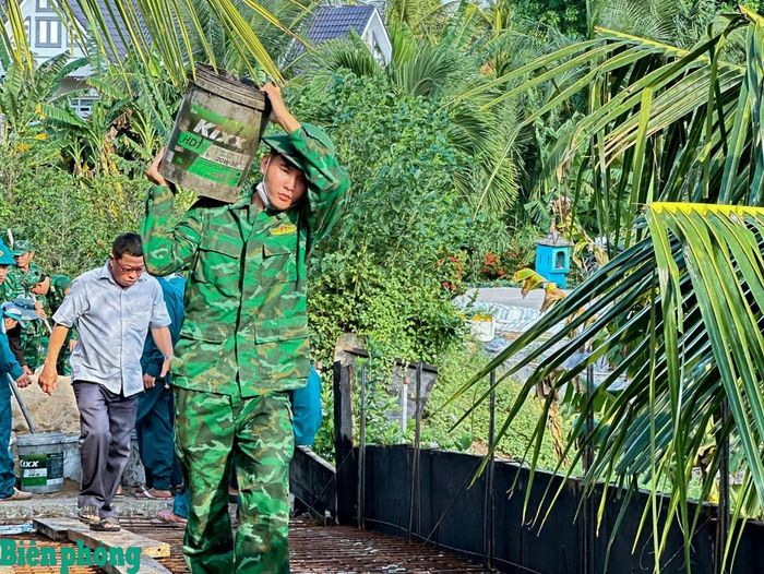 Trong những ngày nắng đổ lửa, những người lính quân hàm xanh Đồn Biên phòng An Thạnh Ba vẫn miệt mài vận chuyển những thùng nguyên vật liệu, phối hợp cùng các lực lượng chuẩn bị đổ mặt cầu Rạch Đùi, thành phố Cần Thơ. Ảnh: Văn Long