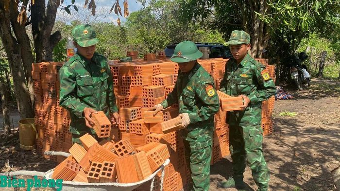 Cán bộ, chiến sĩ Bộ đội Biên phòng tỉnh Gia Lai hỗ trợ vận chuyển vật liệu xây dựng nhà cho bà Rơ Mah Đi, đối tượng con đẻ của người hoạt động kháng chiến bị nhiễm chất độc hóa học tại xã Ia Púch, tỉnh Gia Lai. Ảnh: Thanh Bình