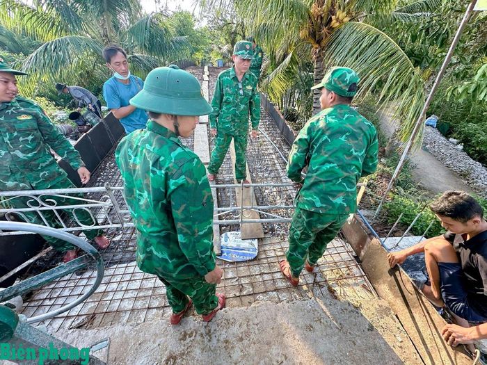 Cán bộ, chiến sĩ Đồn Biên phòng An Thạnh Ba, Bộ đội Biên phòng thành phố Cần Thơ cùng các lực lượng tham gia hỗ trợ ngày công lao động đổ bê tông mặt cầu Rạch Đùi, tại ấp An Quới, xã Cù Lao Dung, thành phố Cần Thơ. Ảnh: Văn Long