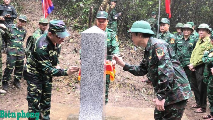 Lãnh đạo hai tỉnh Quảng Trị và Khăm Muồn tô son cột mốc. Ảnh: Hoài Nam