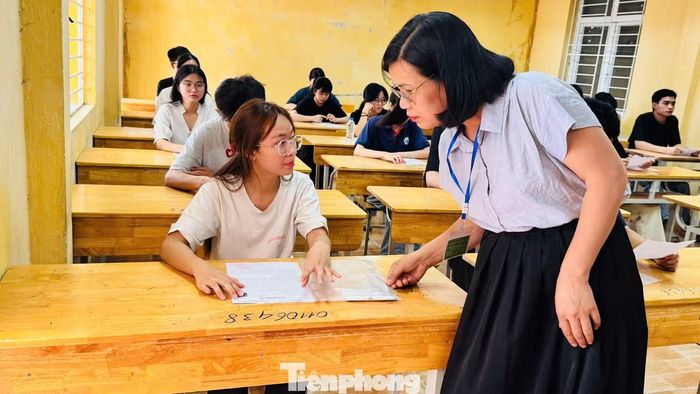 Giám thị hướng dẫn thí sinh tra soát thông tin trên phiếu dự thi. Ảnh Nghiêm Huê