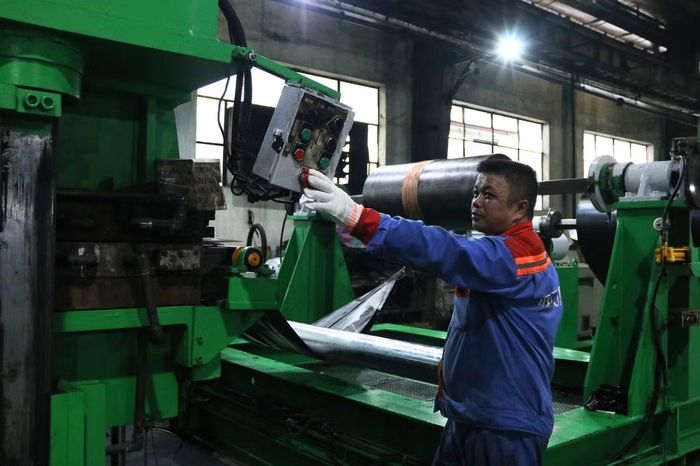 Công nhân vận hành thiết bị sản xuất băng tải lõi vải tại xưởng sản xuất
