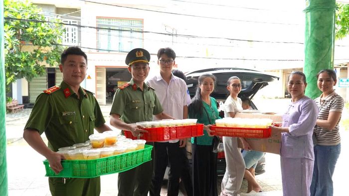 Chị Nguyễn Trần Mỹ Thuyên (thứ hai, từ phải sang) cùng đoàn viên, thanh niên Công an tỉnh mang những suất cơm nghĩa tình đến tận nơi lưu trú của các thí sinh.