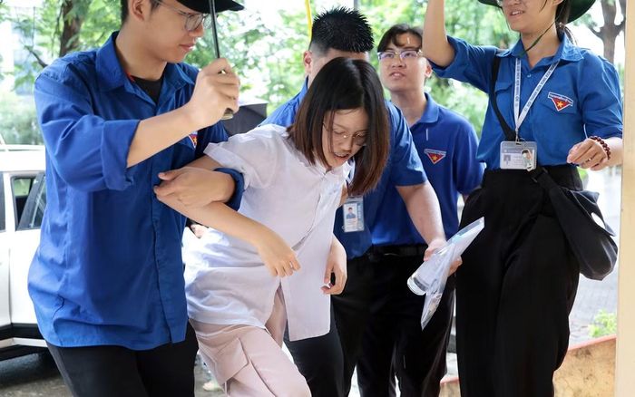 Một nữ sinh tại điểm thi Trường THPT chuyên Nguyễn Trãi gặp sự cố trước ngày thi nên di chuyển khó khăn. Nữ sinh này được các đoàn viên, thanh niên hỗ trợ, dìu vào phòng thi.