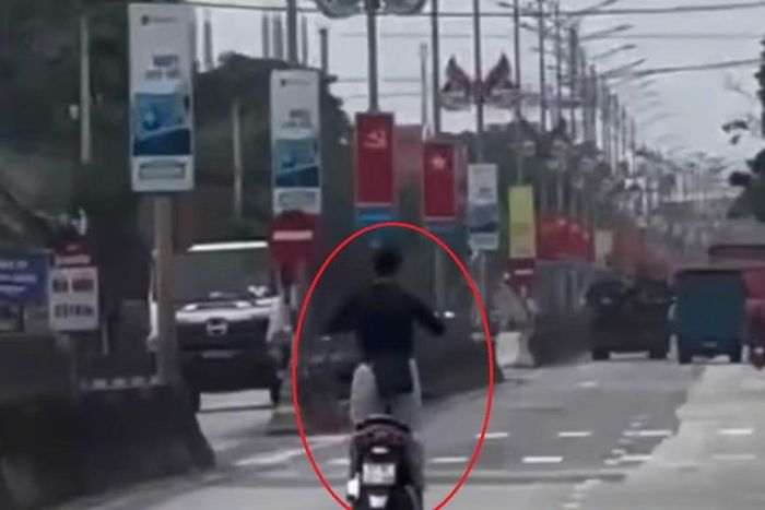 Hình ảnh K. điều khiển xe máy buông hai tay, lạng lách, đánh võng trên Quốc lộ 1A.