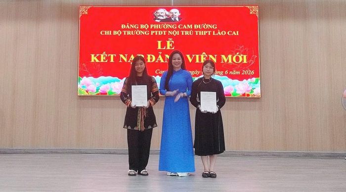 Cô giáo Lê Ngọc Quỳnh trao Quyết định kết nạp Đảng viên cho 2 em học sinh. Ảnh: NTCC