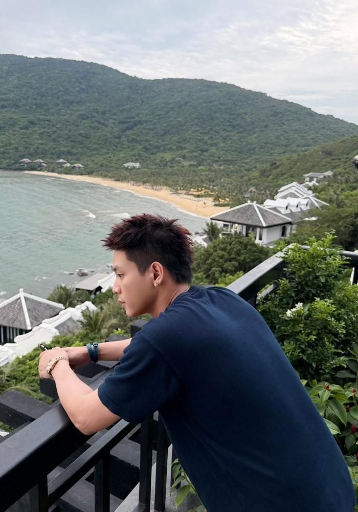 Ca sĩ Quân A.P đứng trên ban công ngắm biển.
