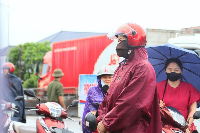 Bất chấp những cơn mưa nhỏ, nhiều phụ huynh vẫn kiên nhẫn chờ đợi con em hoàn thành bài thi.