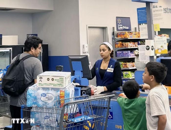 Một gia đình gốc Mỹ Latinh thanh toán hàng hóa tại chuỗi siêu thị Walmart ở thủ đô Washington D.C. (Ảnh: Đoàn Hùng/TTXVN)