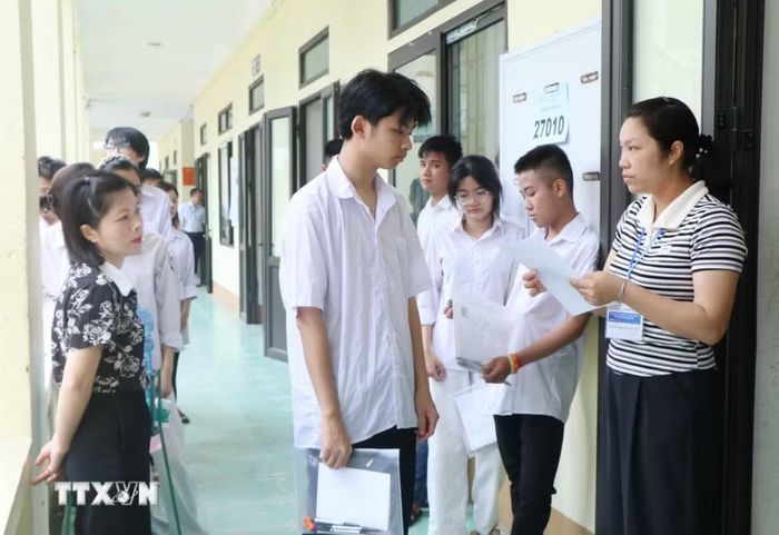 Giám thị tại điểm thi trường THPT Tam Nông (xã Tam Nông, tỉnh Phú Thọ) kiểm tra thông tin thí sinh trước khi vào phòng thi. (Ảnh: Thu Hương/TTXVN)