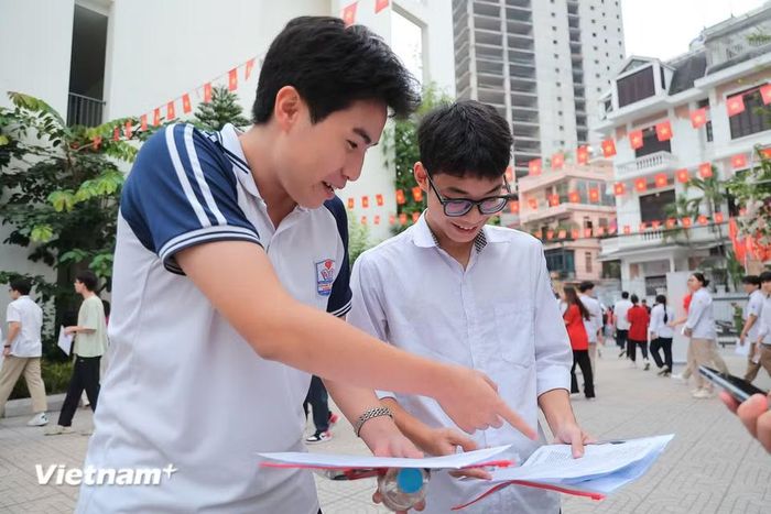 Nhiều em hào hứng đối chiếu, so đáp án ngay sau khi rời khỏi phòng thi của mình. (Ảnh: Hoài Nam/Vietnam+)