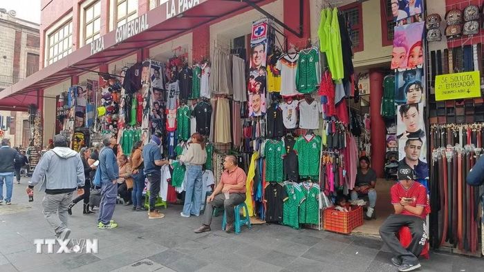 Tiểu thương bày bán áo đội tuyển Mexico trên một tuyến phố đông người qua lại ở thủ đô Mexico City trước giờ khai mạc World Cup 2026. (Ảnh: Phương Lan/TTXVN)