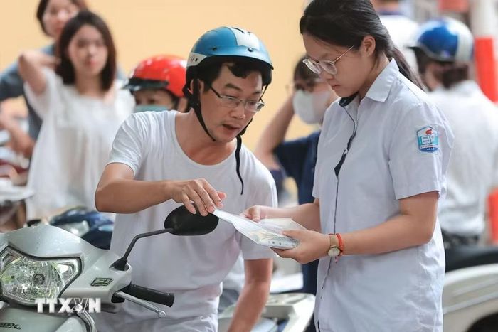 Đồng hành cùng sĩ tử tại điểm thi trường THPT Nguyễn Gia Thiều (Hà Nội). (Ảnh: Minh Quyết/TTXVN)