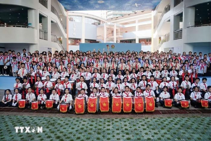 Thiếu niên nhi đồng hai nước Việt-Trung tham gia chương trình chụp ảnh lưu niệm. (Ảnh: TTXVN phát)