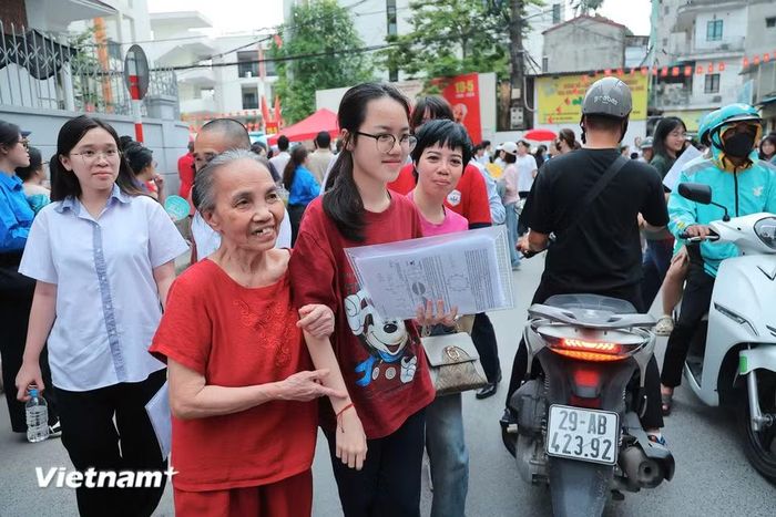 Thấy sỹ tử yên tâm, gia đình cũng thở phào nhẹ nhõm để hòa chung niềm vui với con, cháu. (Ảnh: Hoài Nam/Vietnam+)
