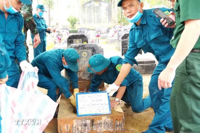 Lực lượng chuyên môn lấy mẫu hài cốt liệt sĩ chưa xác định danh tính tại Nghĩa trang Liệt sỹ xã Sơn Dương (Tuyên Quang). (Ảnhr: TTXVN phát)