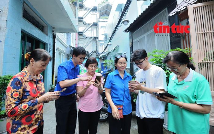 Thanh niên, sinh viên đồng hành với người dân khu phố 22, phường Diên Hồng trong việc sử dụng những ứng dụng hành chính công trên thiết bị di động.
