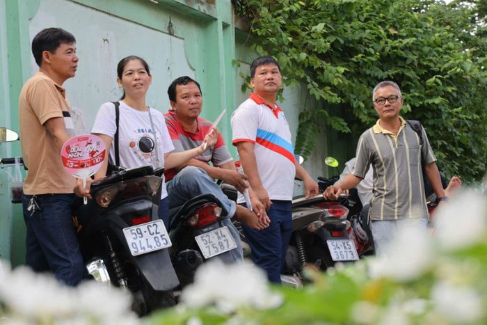 Các phụ huynh đứng chờ con tại điểm thi Trường THPT Trưng Vương, phường Sài Gòn, TP Hồ Chí Minh.