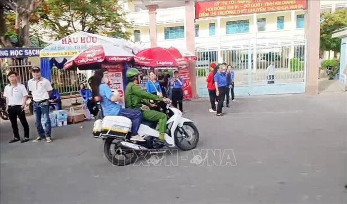 Công an phường Châu Đốc, An Giang tới nhà đưa thí sinh ngủ quên đến điểm thi Trường THPT Chuyên Thủ Khoa Nghĩa kịp thời. Ảnh: TTXVN phát
