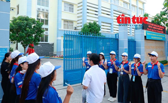 Các sinh viên động viên, cổ vũ thí sinh tham dự kỳ thi THPT quốc gia tại điểm thi Trường THPT Nguyễn Khuyến, phường Hòa Hưng, TP Hồ Chí Minh.