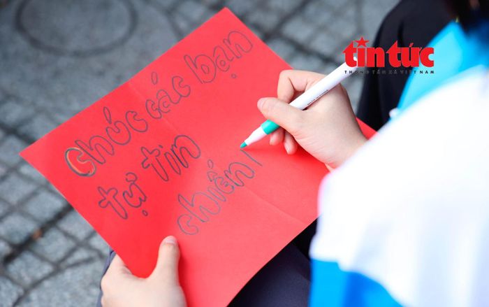 Tình nguyện viên tự tay viết lời chúc đến các sĩ tử tham gia kỳ thi THPT quốc gia.