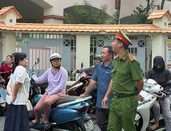 Công an phường Cầu Ông Lãnh (TP Hồ Chí Minh) trò chuyện cùng phụ huynh chờ con tại điểm thi Trường THPT Lương Thế Vinh.