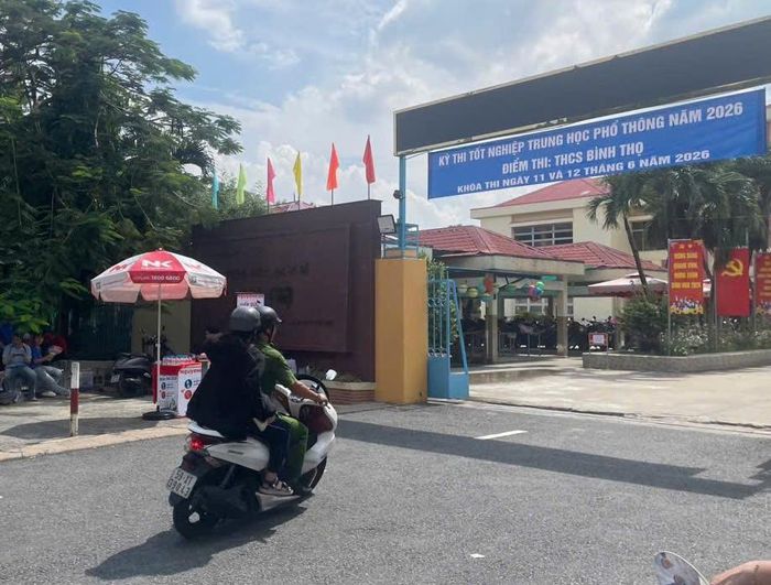 Một chiến sĩ Công an hỗ trợ thí sinh quên giấy báo thi đến điểm thi Trường THCS Trường Thọ, TP Hồ Chí Minh.