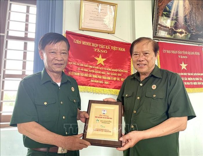 Ông Nguyễn Duy Viên (bên phải), Chủ tịch Hội đồng quản trị Hợp tác xã sản xuất kinh doanh dịch vụ nông nghiệp Thống Nhất (xã Trường Ninh, tỉnh Quảng Trị) nhận Cờ thi đua, Bằng khen của Trung ương và địa phương.